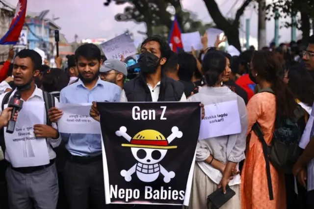 नेपो बेबीज र जेन जी लेखिएको ब्यानरसहित प्रदर्शनमा सहभागी युवा युवती