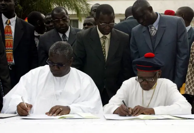 Le défunt leader séparatiste Augustin Diamacoune Senghor (à droite), président du Mouvement des Forces Démocratiques de Casamance (MFDC) et l'ancien ministre de l'Intérieur du Sénégal Ousmane Ngom, signent un accord de paix le 30 décembre 2004 à Ziguinchor.