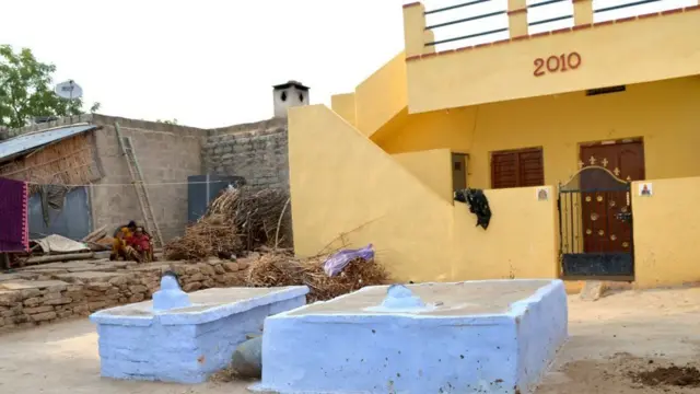 એક ઘરની બહાર બે કબર બનેલી છે