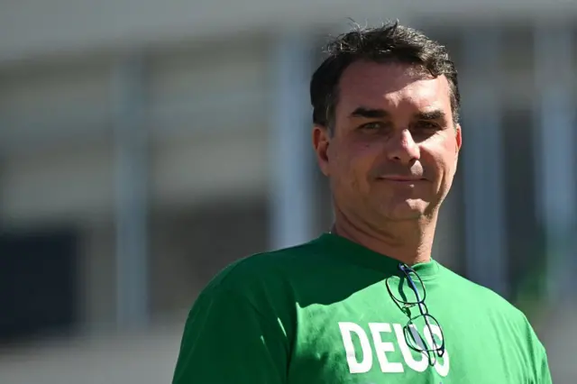 Flavio Bolsonaro com camisa verde com a instrição DEUS