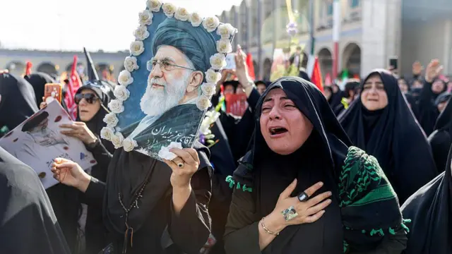 4 Temmuz'da Tahran'da Ali Hamaney'in cenaze törenine katılan kadınlar siyah çarşaflarıyla ve ellerinde Hamaney posteri, bayraklar ve çiçeklerle üzgün bir şekilde ve bazıları ağlarken görülüyor