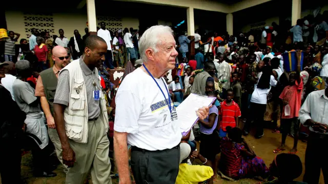 Tsohon shugaban Amurka Jimmy Carter yana fitowa daga wurin zaɓe a Monrovia babban birnin Liberia a 2005. 