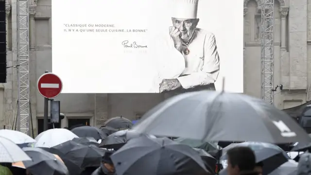Pantalla con la imagen de Bocuse proyectada afuera de la catedral.