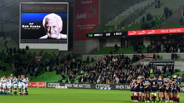 球员和观众在澳大利亚一场榄球赛前，为霍克默哀。