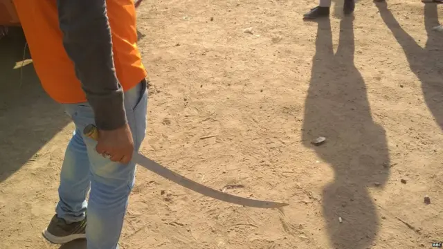 रामलीला मैदान के बाहर तलवार लिए खड़ा एक युवा