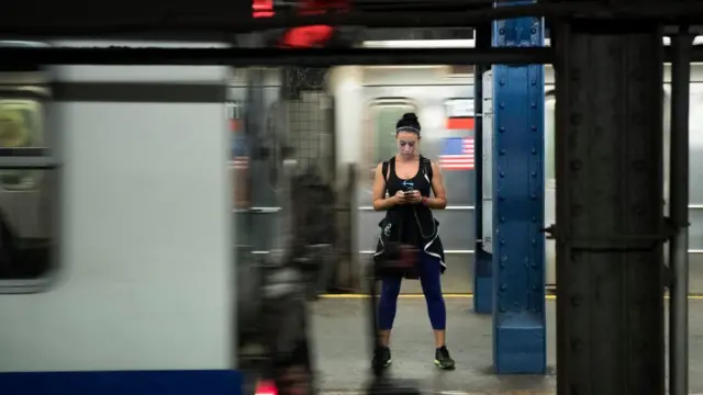 地铁站一位女士看手机