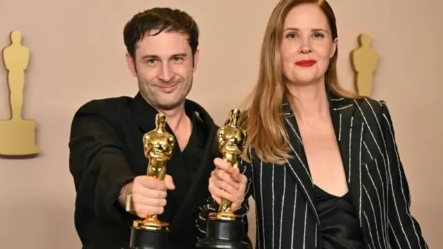 La réalisatrice et scénariste française Justine Triet et Arthur Harari posent en salle de presse avec l'Oscar du meilleur scénario original pour "Anatomie d'une chute " .