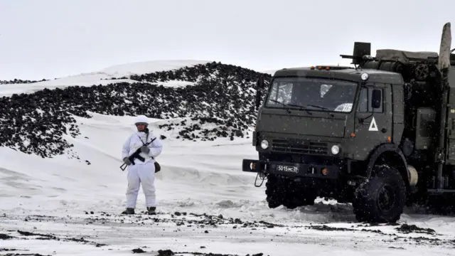Un militar ruso monta guardia junto a un camión militar en la isla de Alexandra Land, parte del archipiélago de Franz Josef Land, el 17 de mayo de 2021.