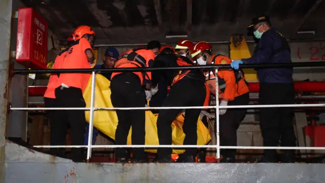 Sejumlah petugas mengangkat kantong berisi jenazah korban kebakaran KM Mutiara Sentosa II setibanya di Dermaga Jamrud Utara, Pelabuhan Tanjung Perak, Surabaya, Jawa Timur, Senin (03/08).