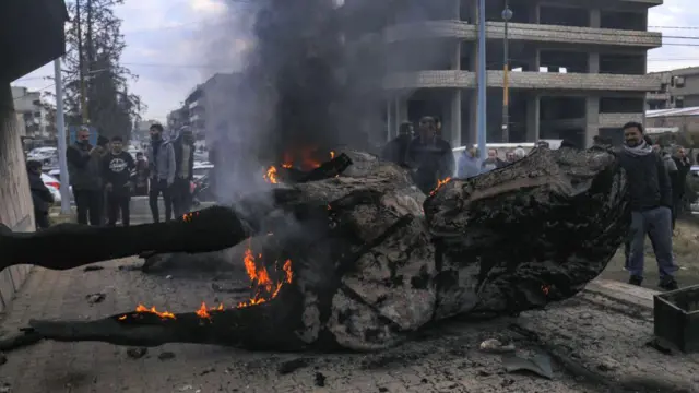 Люди у искорёженных обломков статуи