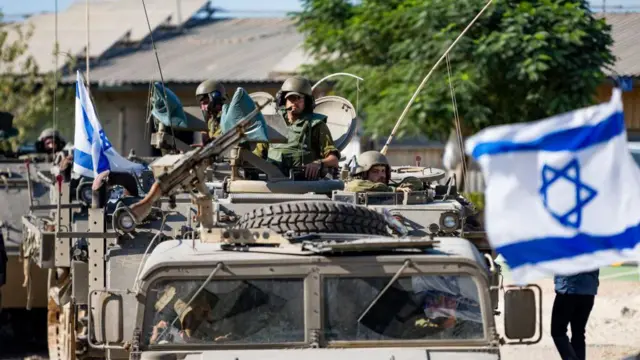 Tentara IDF mengendarai truk pengangkut personel lapis baja pada 17 Oktober 2023 di Be'eri, Israel