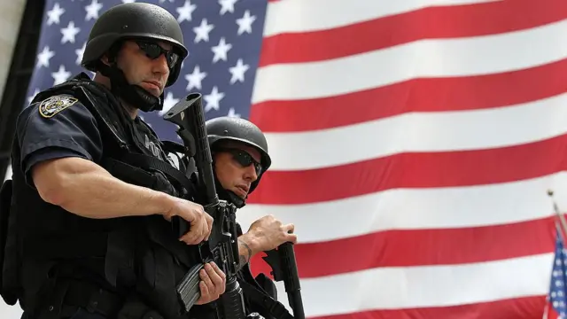 Policías en Estados Unidos, frente a una bandera de EE.UU.