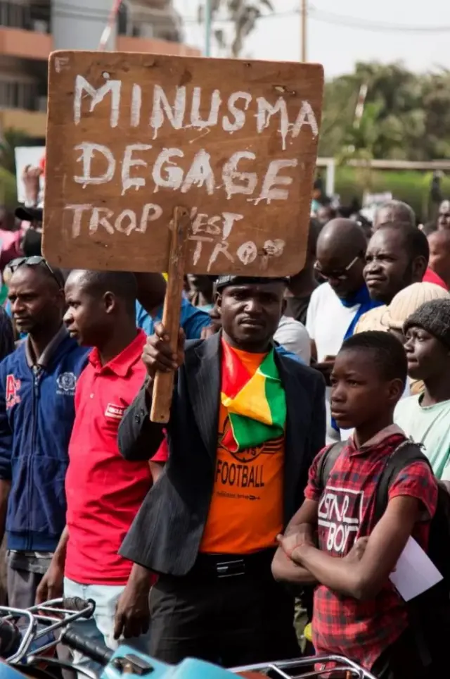 Des hommes tiennent des pancartes portant l'inscription "MINUSMA Dégage" lors d'une manifestation contre les forces françaises et onusiennes basées au Mali en 2020.