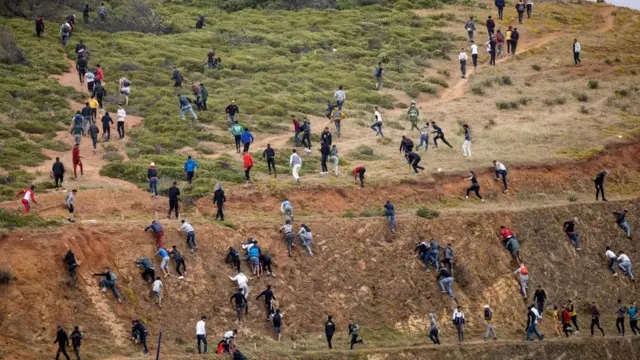 Del lado marroquí, los migrantes tratan de evitar a la policía local para llegar a la frontera con España.
