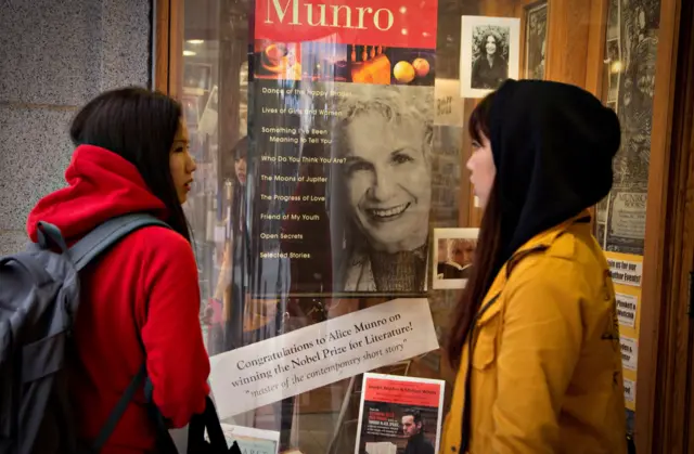 Dos mujeres frente a una vitrina de la librería Munro Books