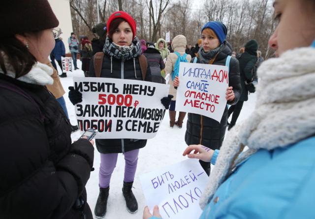 Proets di taman Moskow membawa papan bertuliskan hukuman untuk memukul istri adalah denda 5.000 roubles (Rp1 juta)