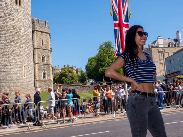 молодая женщина улыбается у стен Виндзорского замка