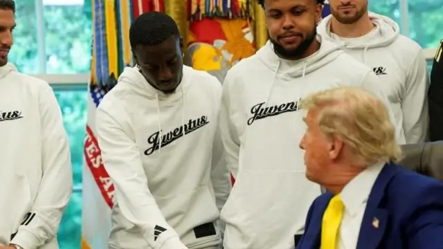 Timothy Weah, vistiendo un buso blanco con el logo de Juventus, le da la mano al presidente Donald Trump.