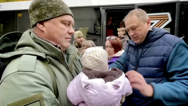 Nghị sĩ Nga Igor Kastyukevich (trái) tổ chức đưa trẻ em lên xe buýt