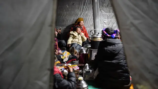 西藏日喀则拉孜县某地村民在临时搭建的帐篷内准备过夜(中新社图片7/1/2025)