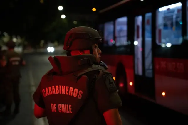 Un carabinero chileno delante de un autobús.