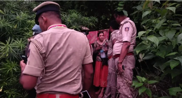 Hint polisi üniformalar içinde ormanlık alanda bir kadınla konuşuyor