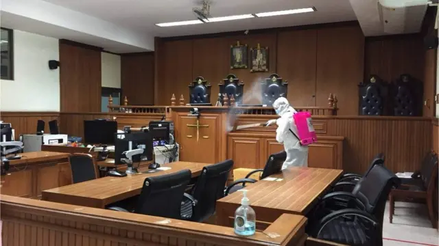 เจ้าหน้าที่ฉีดพ่นฆ่าเชื้อโควิด-19 ในห้องพิจารณาคดี ที่ศาลอาญา เมื่อ 12 พ.ค.