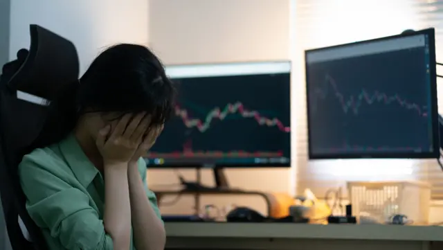 Hình minh họa người ngồi trước máy tính có thông tin chứng khoán
