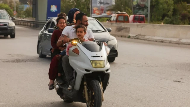 Five pipo dey ontop one motorbike along highway for Sidon 