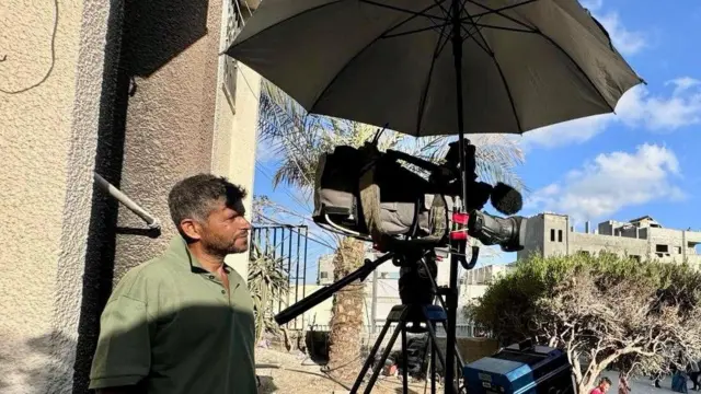 المصور الفلسطيني حسام المصري مع كاميرته أثناء عمله في مستشفى ناصر في خان يونس جنوب قطاع غزة