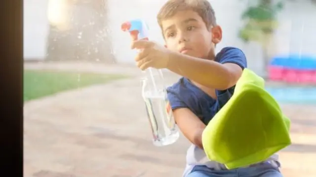 Menino limpando janela