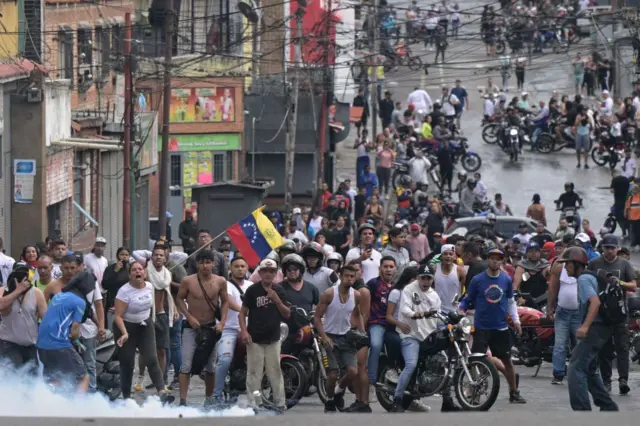 Jóvenes en moto en una barriada popular en Caracas protestando