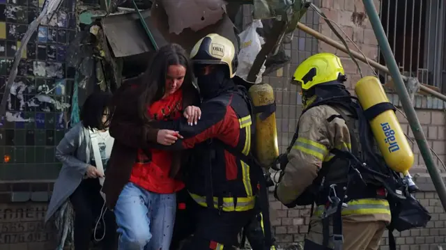 Equipos de emergencia socorren a los residentes de los edificios impactados por el ataque.