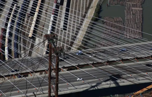 Wires cross over the lines of the road with train lines further underneath