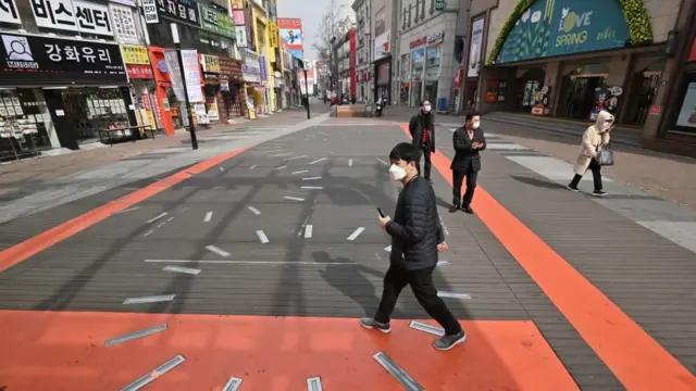 দেগুর একটি শপিং স্ট্রিটে হাতেগোনা কয়েকজন লোক।