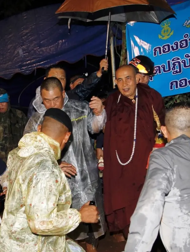 ครูบาบุญชุ่ม พระสงฆ์จากรัฐฉานของเมียนมา (กลาง) เดินทางมาถึงเมื่อวันที่ 29 มิ.ย. 2561 เพื่อประกอบพิธีทางศาสนาในการช่วยค้นหาทีมนักฟุตบอลรุ่นเยาว์ที่สูญหายพร้อมกับผู้ฝึกสอนที่ถ้ำหลวง