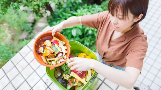 žena baca hranu u kompost