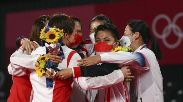 圖為女雙頒獎儀式後，中國組合與韓國組合同獲得金牌的印尼選手一同擁抱。