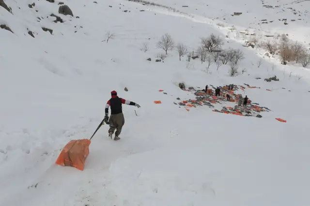 Mladi nosač vuče svoj teški tovar niz padinu prema mestu gde će napraviti kratku pauzu a zatim džakove ponovo natovariti na leđa.