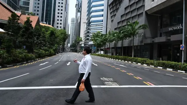 Um homem caminhacasinoonlineuma rua vaziacasinoonlineCingapura