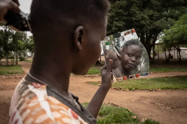 South Sudanese asylum seeker Nyalada Gatkouth Jany who tried to cross the Mediterranean Sea four times and went into prison in Libya, gets her hair cut at Gashora Emergency Transit Centre in Gashora, Rwanda.