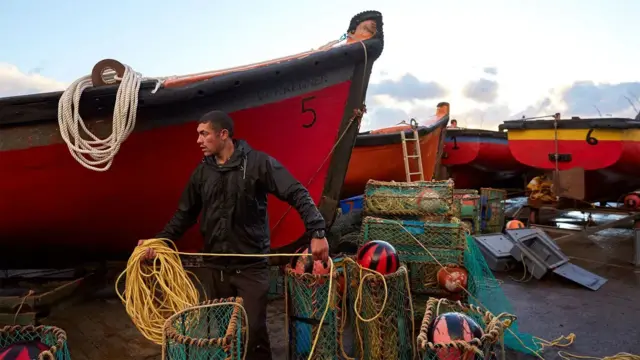 Pescador preparando todo entre barcos