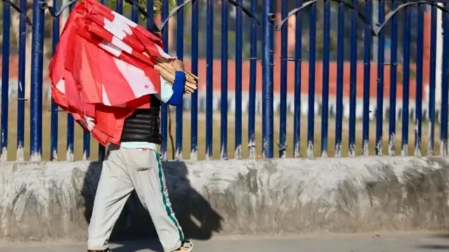 एक व्यक्ति कांग्रेसको झन्डाहरू बोकेर हिँड्दै