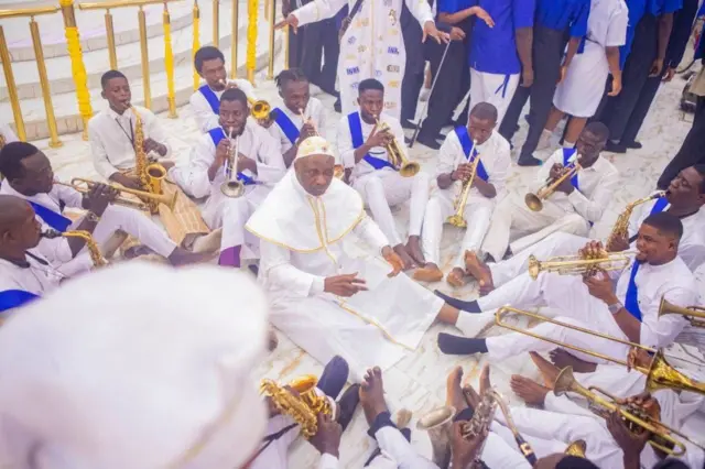 Primate Elijah Ayodele laaarin awọn to n fọn fere, gbogbo wọn wọ aṣọ funfun to ni ipele alawọ aro lori.