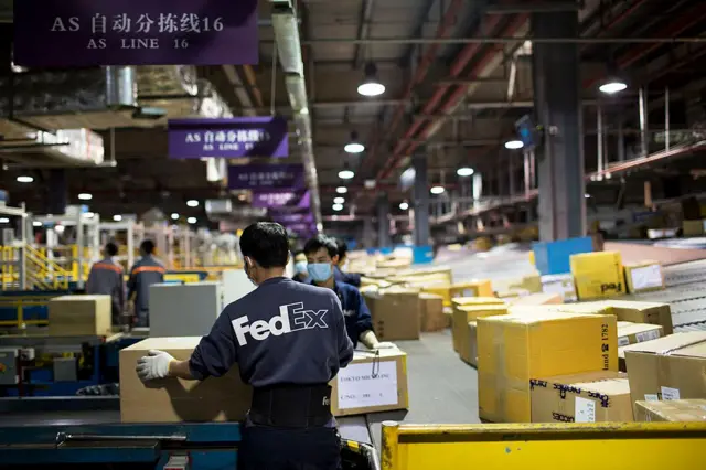 Trabajadores de FedEx organizando paquetes