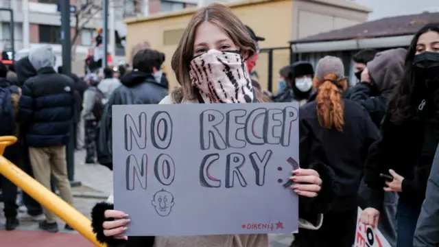 Seorang pengunjuk rasa memegang plakat bertuliskan 'No Recep No Cry', plesetan dari judul lagu hit Bob Marley, No Woman No Cry.
