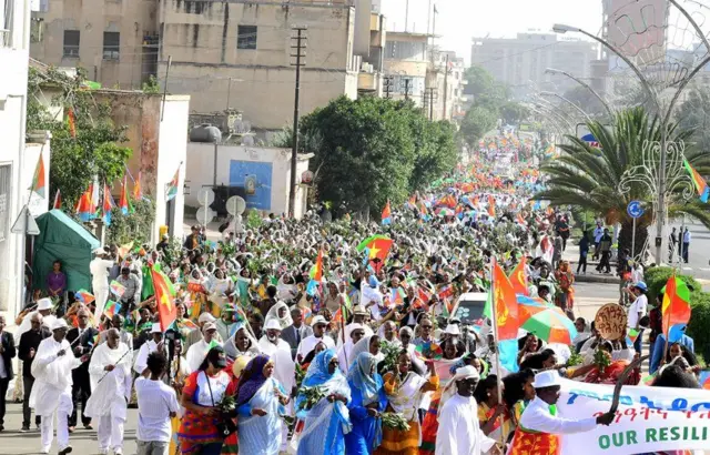 ደድሕሪ ካርኒቫል ክስዕቡ ዝተራእዩ ባንዴራታትን ቆጽልን ዝሓዙ ብኣሽሓት ዝቚጸሩ ኣቦታትን ኣዴታትን ኣብ ጐደና ሰማእታት