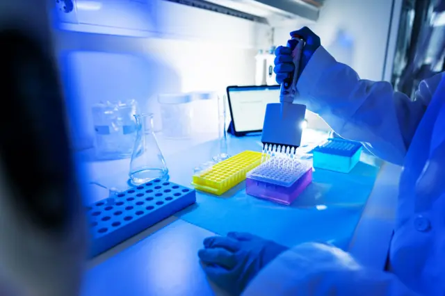 Cientista manipulando amostras de DNA em laboratório