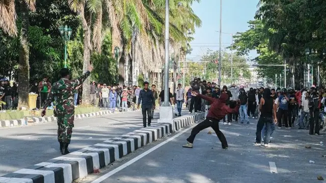 Seorang prajurit TNI AD berusaha menghentikan pengunjuk rasa melempar ke arah gedung DPRD Sultra di Kendari, Sulawesi Tenggara, Senin (1/9/2025).