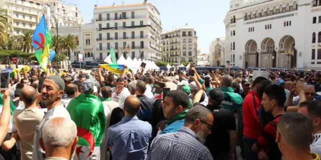 متظاهرون أمازيغ يرفعون العلم الأمازيغي خلال احتجاجهم في العاصمة الجزائرية